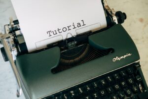 tutorials, green and black typewriter with white printer paper