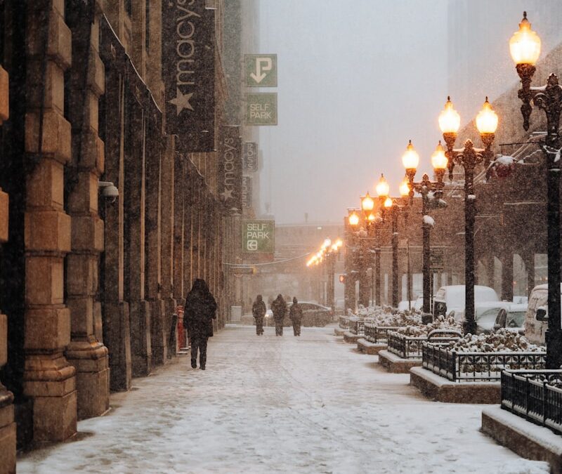 A snowy street with people walking down it